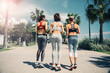 © Yakobchuk Olena - Cheerful three young women are running on the road in park. Focus on their back