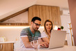 © Nebojsa - Serious young couple paying their bills online from home