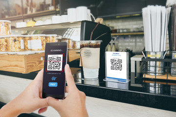 Wall Mural - Qr code payment, E wallet , cashless technology concept. Man scaning  tag in Coffee accepted generate digital pay without money.