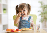 Fototapeta Pomosty - kid child girl eating healthy food at home