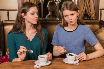 Two happy women drinking coffee in cafe