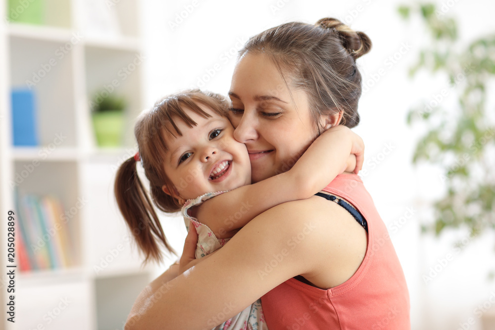 love and family concept - happy mother and child daughter hugging at home - obrazy, fototapety, plakaty 