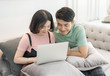 © Vuttigrai - Couple Use Laptop Computer Together In Living Room, Happy Smiling Woman,