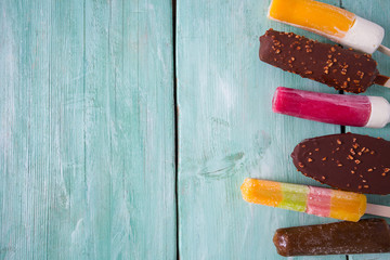 Wall Mural - various ice cream popsicles on wooden surface