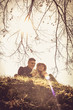 © liderina - Portrait of young couple sitting in nature.