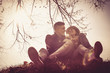 © liderina - Portrait of young couple sitting in nature.