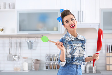 Poster - Funny young housewife with frying pan in kitchen