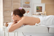 © New Africa - Beautiful young woman having massage with body scrub in spa salon