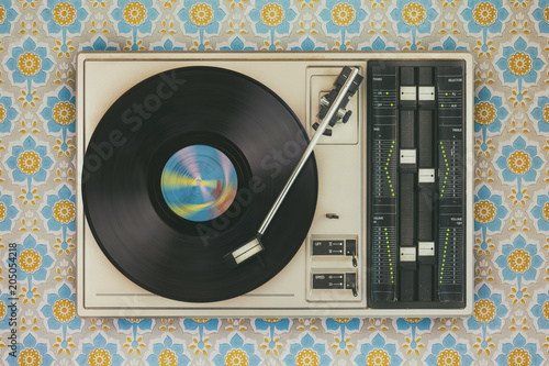 Fotografía Record player on top of flower wallpaper