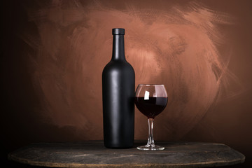 Wall Mural - Red wine bottle on a wooden brown background