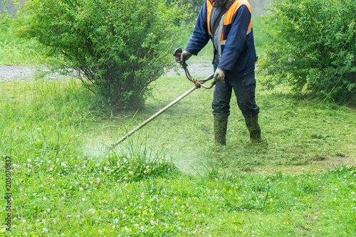 Fotografía  The gardener cutting grass by lawn mower