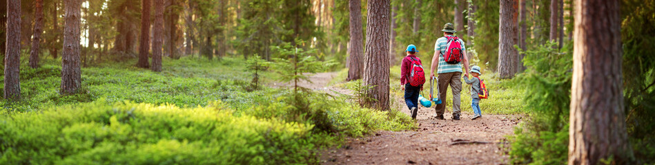 father and boys going camping with tent in nature