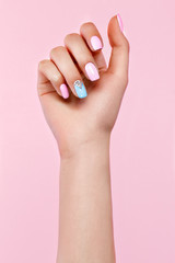 Canvas Print - Beautiful pink and blue manicure with crystals on female hand. Close-up. Picture taken in the studio