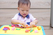 © yAOinLoVE - Cute smiling little Asian 18 months old toddler baby boy child having fun playing modeling clay / play dought at play school / child care, Montessori education Creative play for toddlers concept