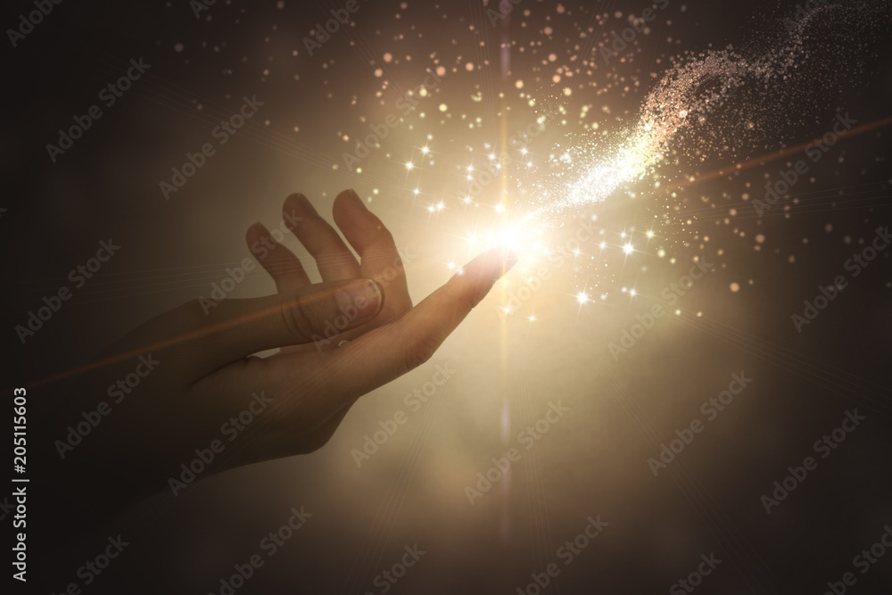 A hand giving the flow of energy. Magic, fantasy. Glowing particles - obrazy, fototapety, plakaty 
