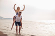 © Mediteraneo - Happy couple in love on beach summer vacations. Joyful girl piggybacking on young boyfriend having fun.