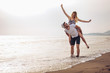 © Mediteraneo - Happy couple in love on beach summer vacations. Joyful girl piggybacking on young boyfriend having fun.