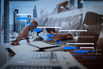 Wall Mural - designer hand working and smart phone and laptop on wooden desk in office