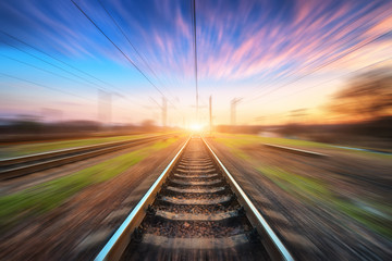 Wall Mural - railway station with motion blur effect at sunset. blurred railroad. industrial conceptual landscape