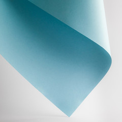colored blue paper sheet on grey background