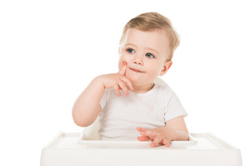 adorable little boy sitting in highchair isolated on white background