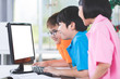© sirikorn - Close up of Smiling asian pupils using a desktop computer.