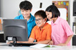 © sirikorn - Close up of Smiling asian pupils using a desktop computer.