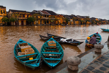 Wall Mural - Hoi An, Vietnam. Street view with traditional boats on a background of ancient town