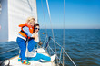 © famveldman - Family sailing. Mother and child on sea sail yacht.