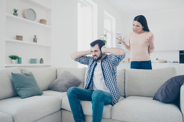 Wall Mural - Portrait of aggressive discontent woman gesturing with hands making the brain yelling arguments to her boyfriend who cover close his ears and ignore couple having scandal fight