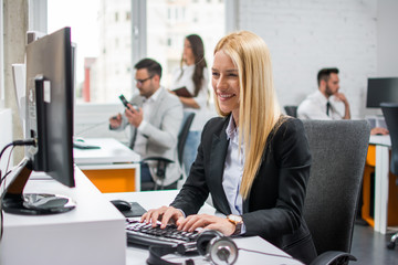 Wall Mural - Smiling blonde young woman working in office