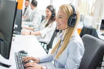 Wall Mural - Beautiful blonde woman telephone operator talking with customer in call center