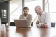 © Westend61 - Two businessmen sharing laptop in conference room