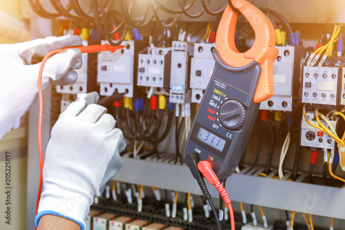 Fotografia electrician measurements with multimeter tester in control panel.