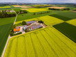 Blühende Rapsfelder (Brassica napus), Gehöft mit Solarstrom und Biogas, Kreis Friedberg, Wetterau, Hessen, Deutschland