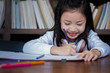 © I Believe I Can Fly - cute girl smiled and sitdown to drawing a book in the library, children concept, education concept