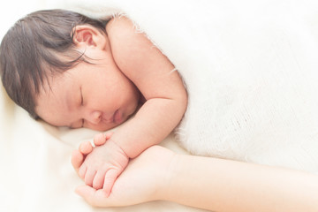 Wall Mural - hand of a newborn baby in the hand of a parent dad