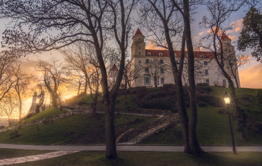 Wall Mural - Bratislava Castle or Bratislavsky Hrad through the Trees at Sunset. The Main Castle of Capital City of Slovakia.