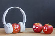 One apple in wireless headphones listening to music, two apple envy him. music concept. psychology of attitude