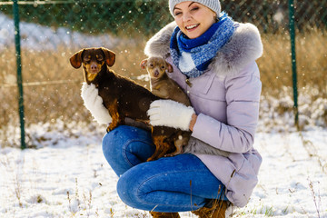 Woman playing with dogs during winter