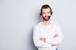 Portrait with copyspace, empty place for advertisement of stylish cheerful operator with headset with microphone on head and crossed arms isolated on grey background