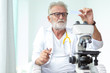 © thbangkok - Doctor older or seriously scientist working with a microscope in Laboratory.