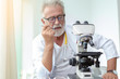 © thbangkok - Doctor older or seriously scientist working with a microscope in Laboratory.