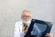 © thbangkok - Senior medical doctor or chief doctor or Surgeon are checking skull of human head via x-ray film In examination room with copy space.