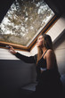 © ADDICTIVE STOCK - Young woman looking in window