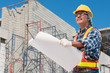 © ZhouEka - Senior Asian civil engineer wearing safety jacket uniform and glove holding construction blueprint to check and follow up the proceed in construction area,
