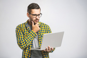 Confident business expert. Confident young handsome man in shirt holding laptop while standing against white background