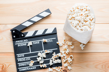 video clapper and salted popcorn top view on wooden boards