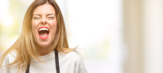 Canvas Print - Shop owner woman wearing apron stressful, terrified in panic, shouting exasperated and frustrated. Unpleasant gesture. Annoying work drives me crazy