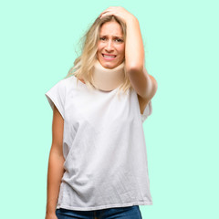 Wall Mural - Young injured woman wearing neck brace terrified and nervous expressing anxiety and panic gesture, overwhelmed